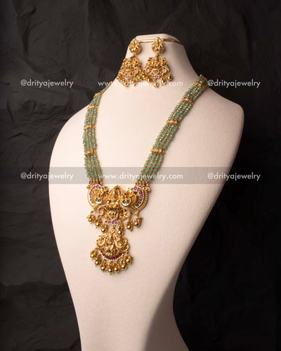 Elegant green beads haram set with a gold-plated Lakshmi Devi pendant and matching earrings.