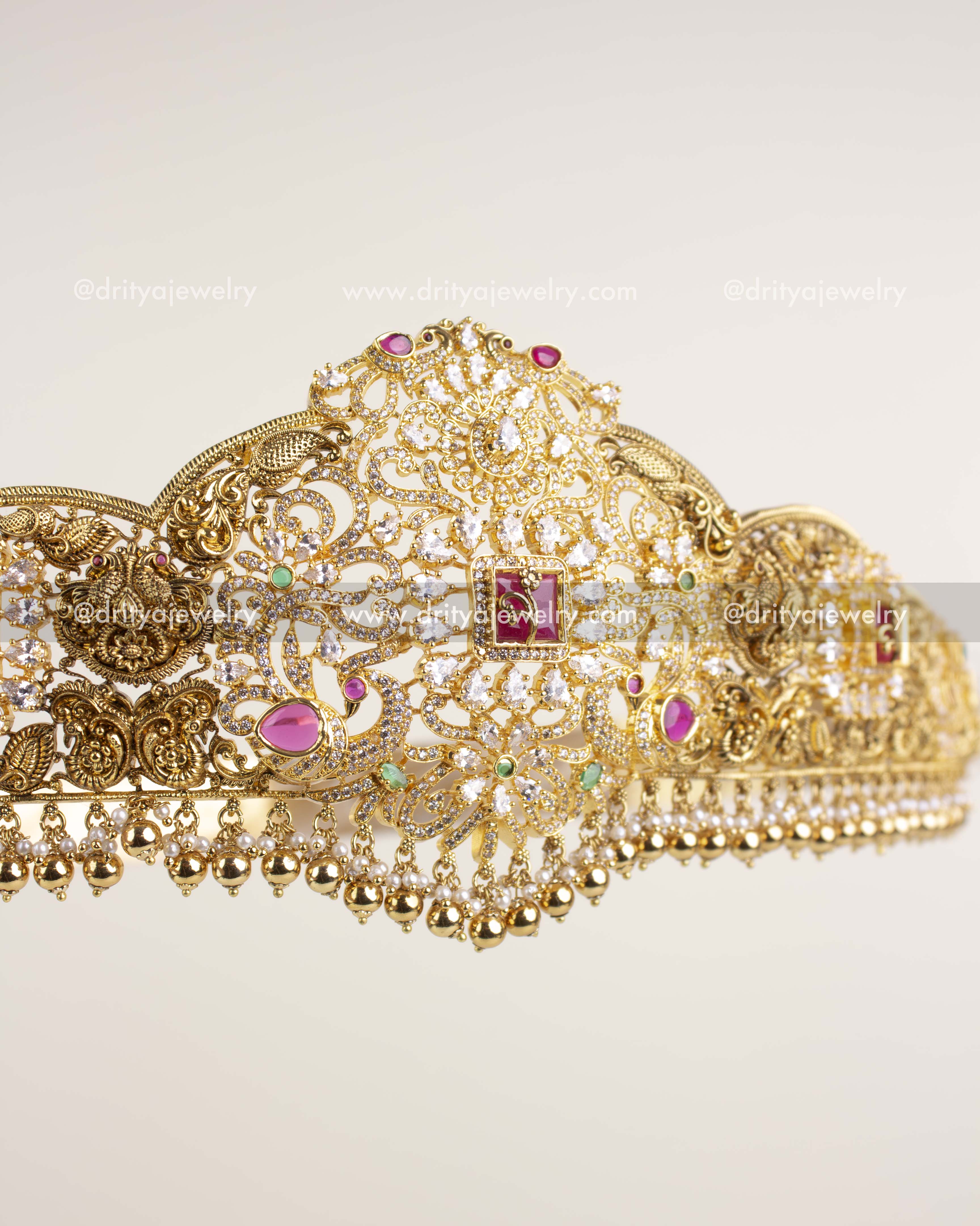 Detailed side view showing nakshi carvings, ruby stones, and golden bead drops on waist belt.