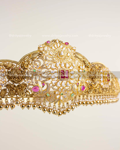 Detailed side view showing nakshi carvings, ruby stones, and golden bead drops on waist belt.