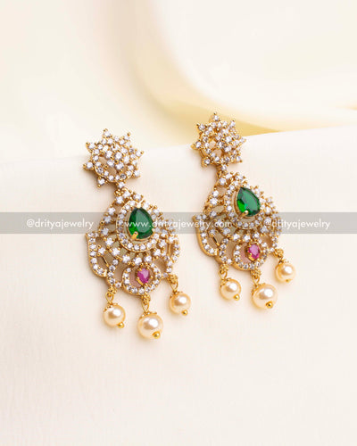 Gold-tone CZ dangler earrings featuring green teardrop, pink gemstone, and pearl drops.