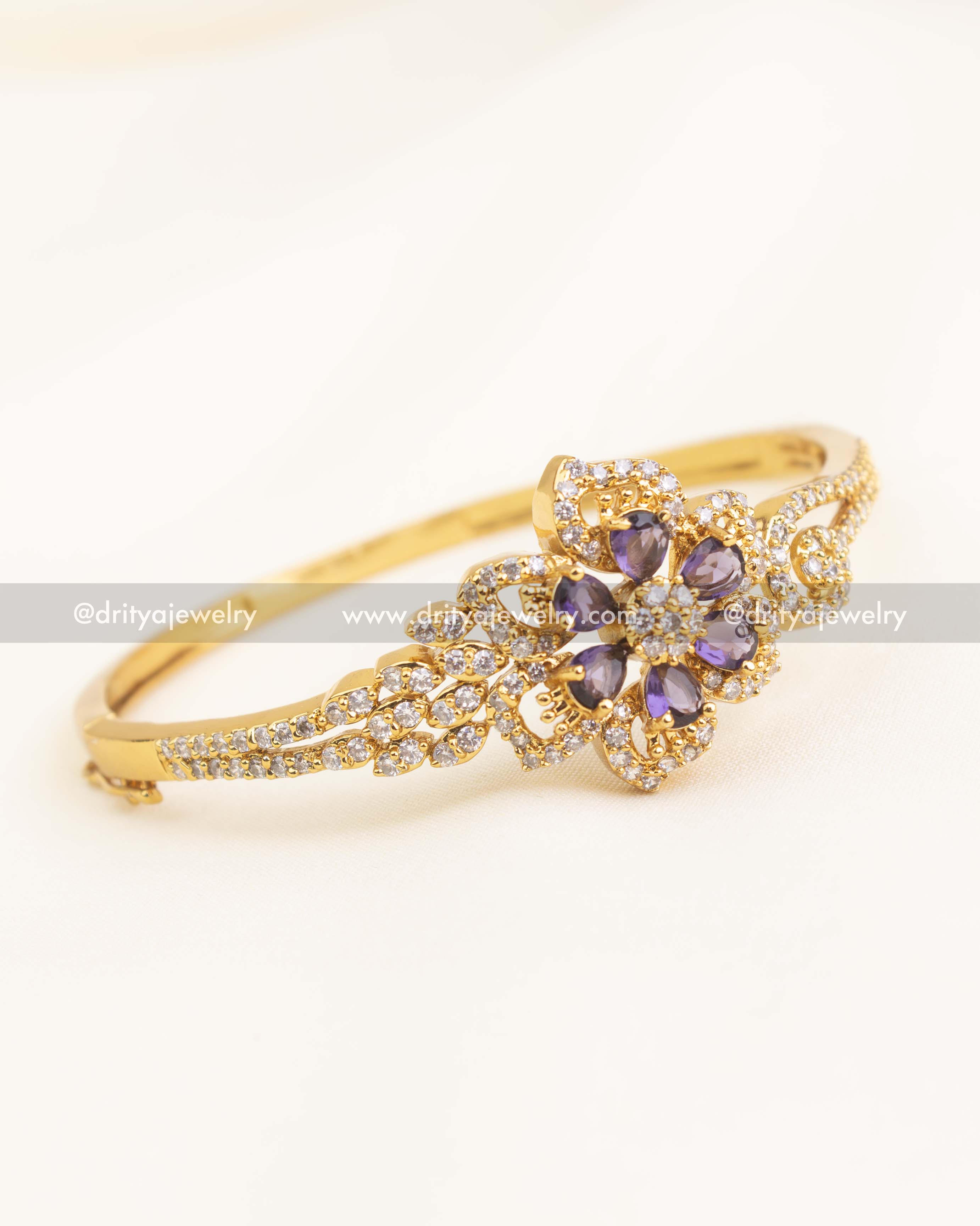 Gold openable kada with purple teardrop stones and CZ floral centerpiece.