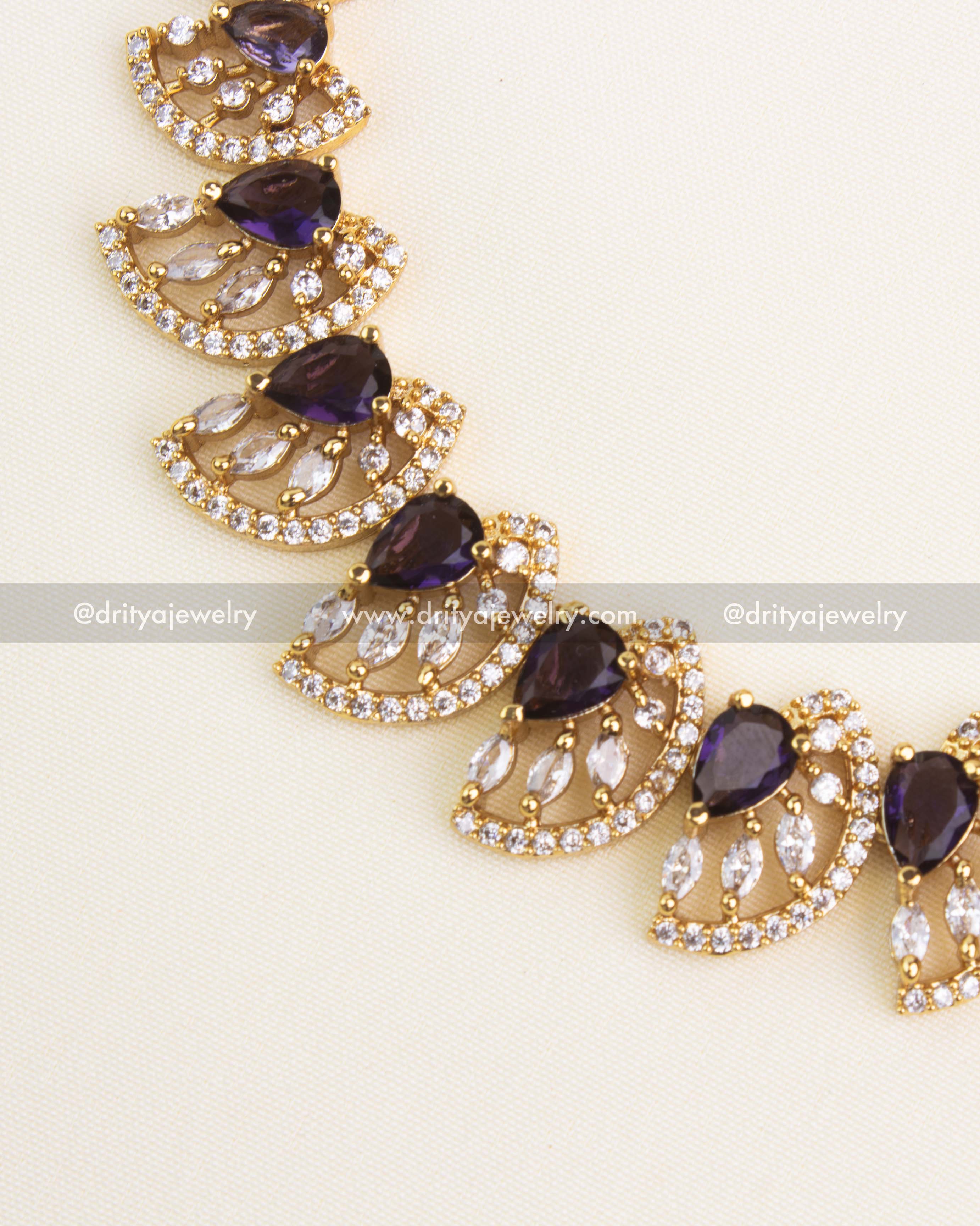 Close-up of purple teardrop stones with CZ border detailing.