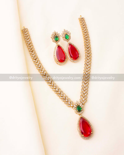 Gold-tone short necklace with red teardrop pendant, green stone detail, and matching earrings.