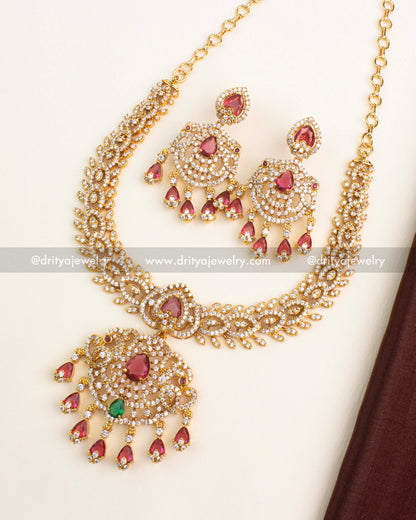 Gold-plated CZ necklace set with ruby red and emerald green stones and matching earrings.