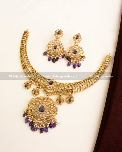 Short gold-plated necklace set featuring CZ stones, purple center drops, and matching earrings.