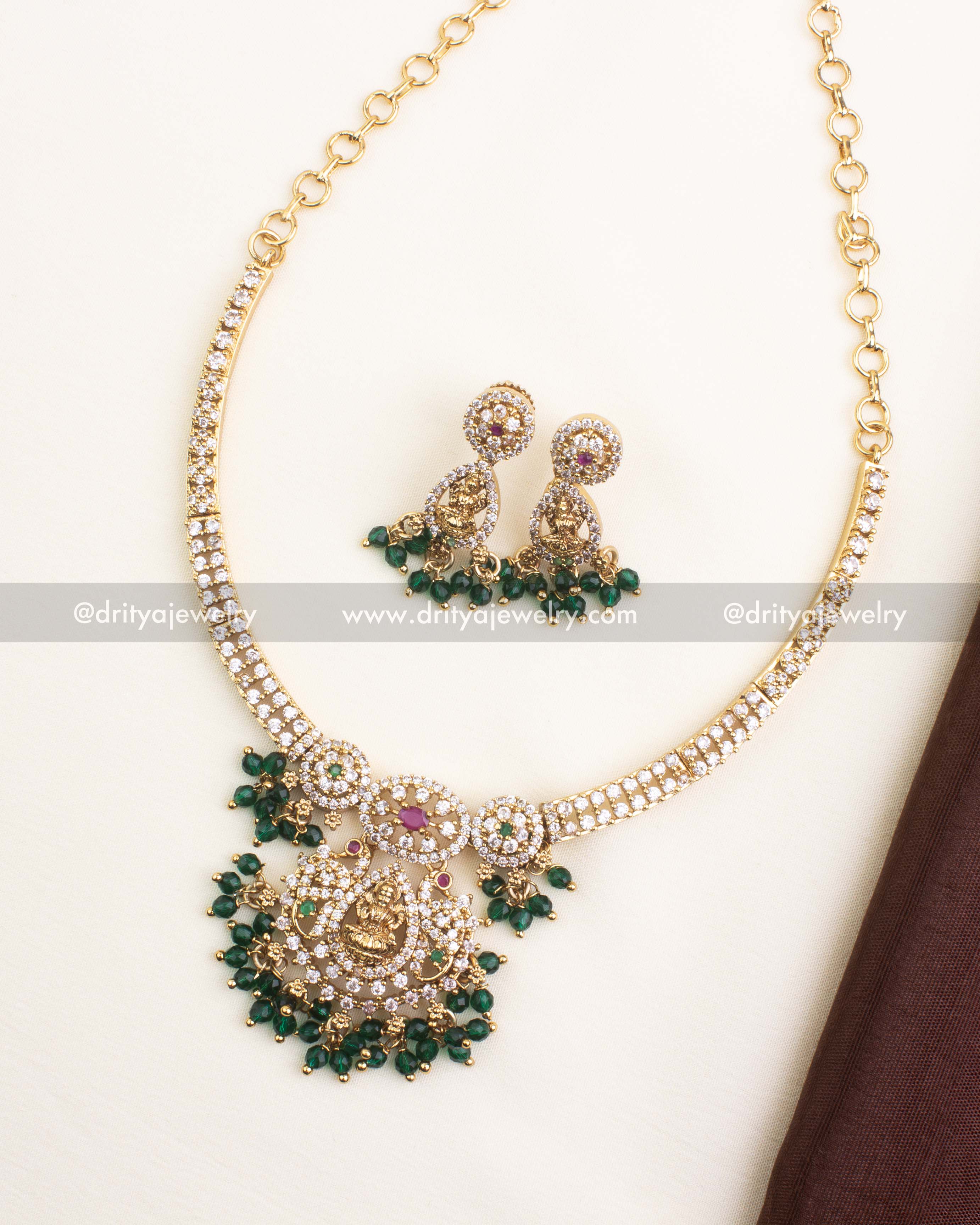 Gold-plated CZ temple short necklace featuring Lakshmi pendant, ruby-emerald accents, and green bead drops.