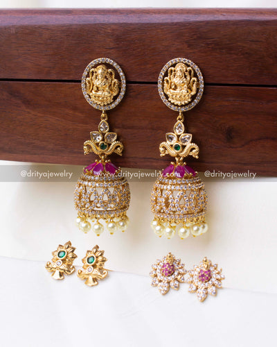 Gold-plated jhumka set with intricate designs and interchangeable floral, peacock, and Lakshmi studs.