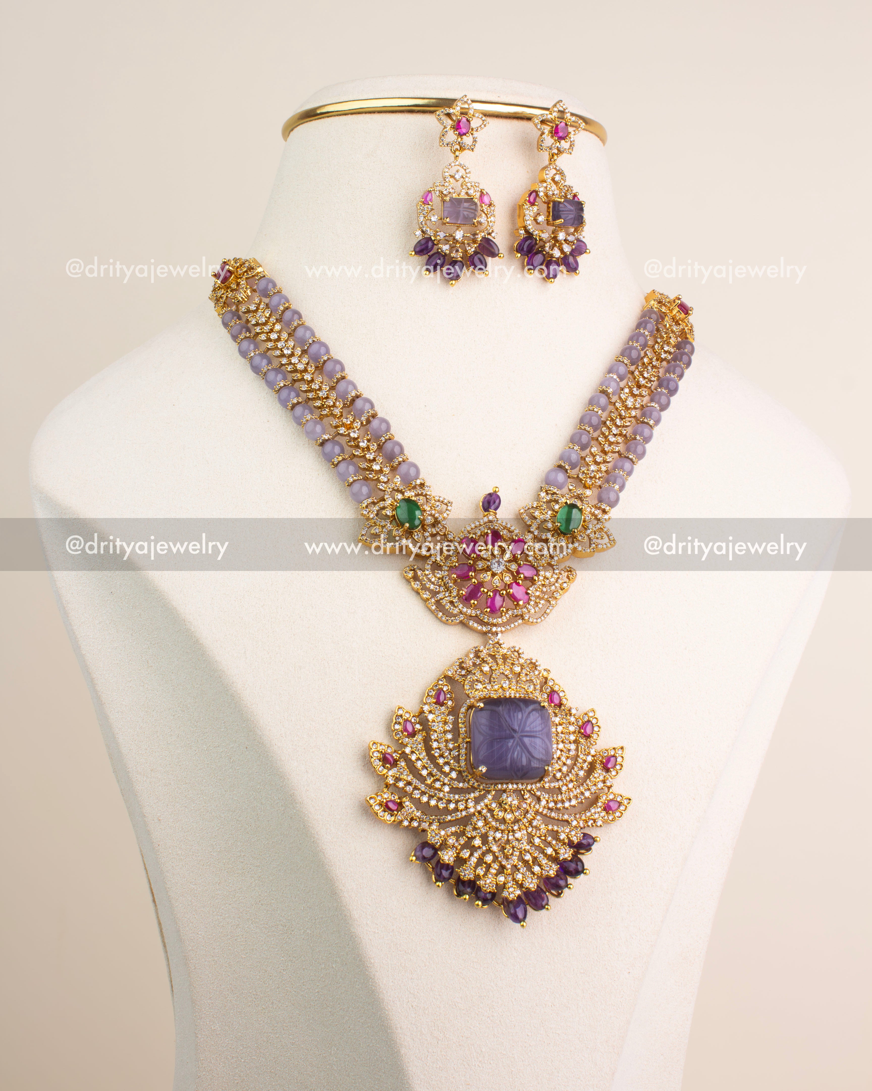 Gold finish necklace set with carved lavender pendant, pink floral design, and matching earrings.