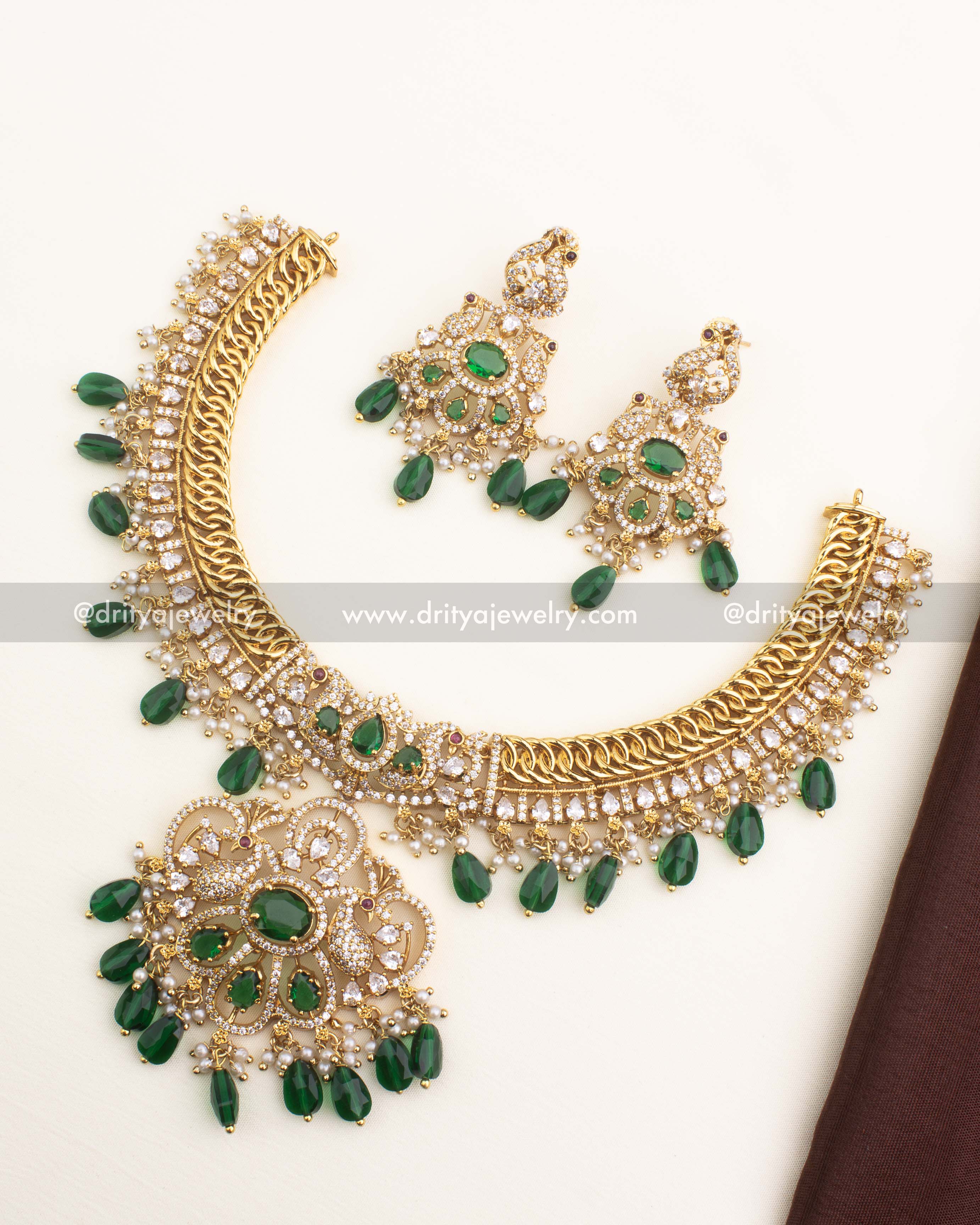 Jalebi-style gold-plated short necklace with CZ stones, pearl clusters, and emerald droplet accents from Dritya Jewelry.