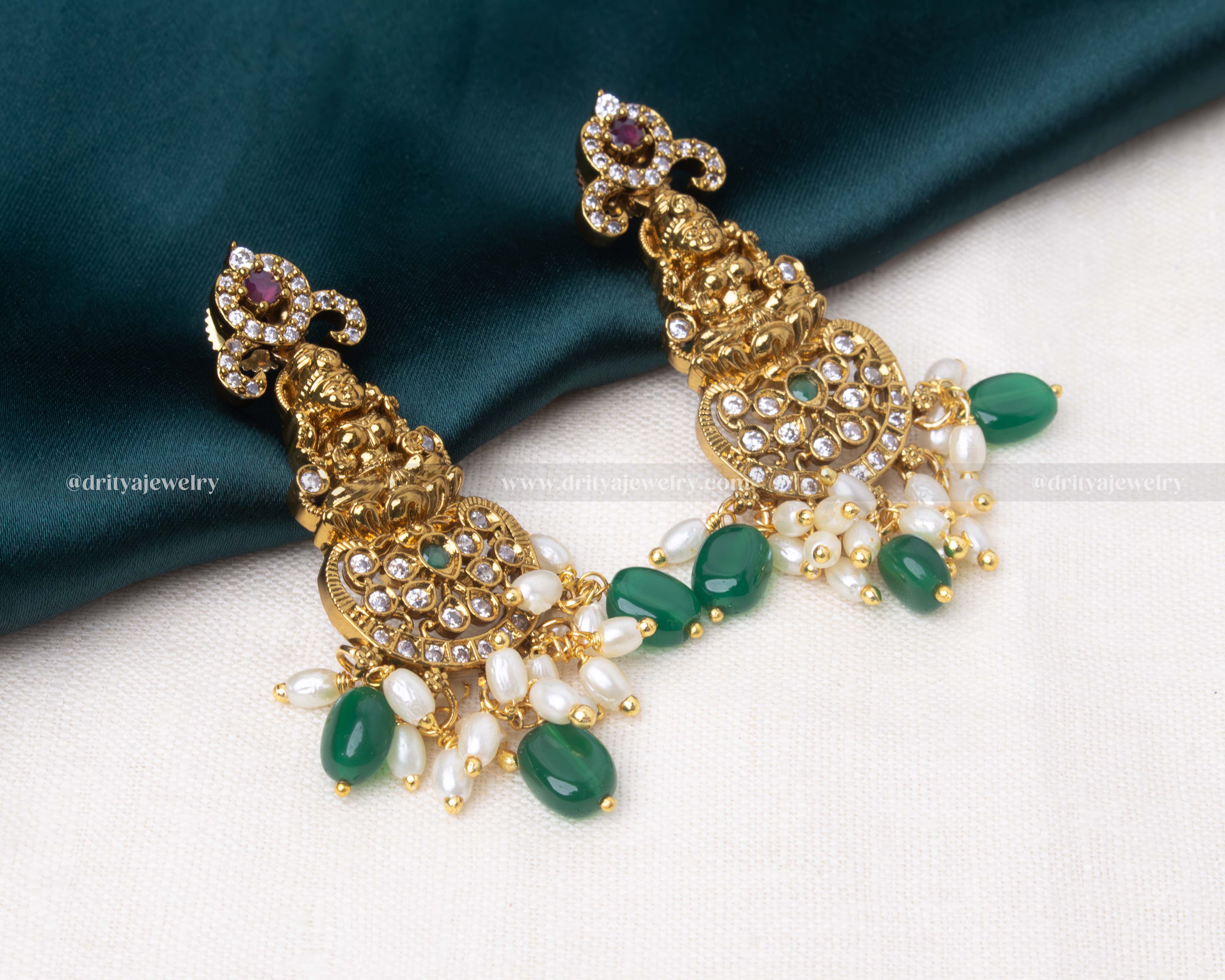 legant short necklace with Lakshmi motif, antique gold polish, and pearl and bead detailing, paired with matching earrings in emerald green or ruby red.