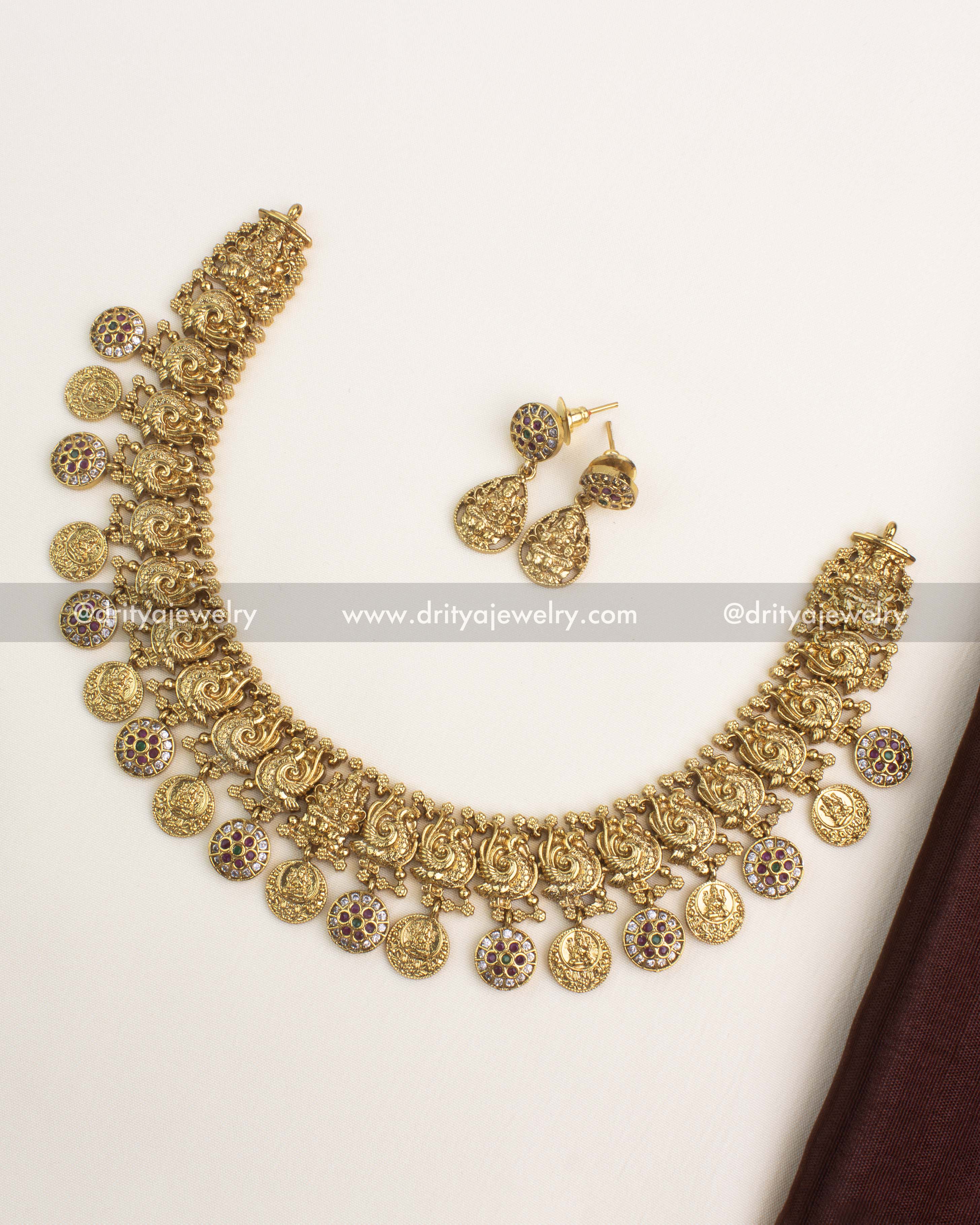 Antique gold temple necklace set featuring Lakshmi coin motifs, CZ stones, and matching earrings.