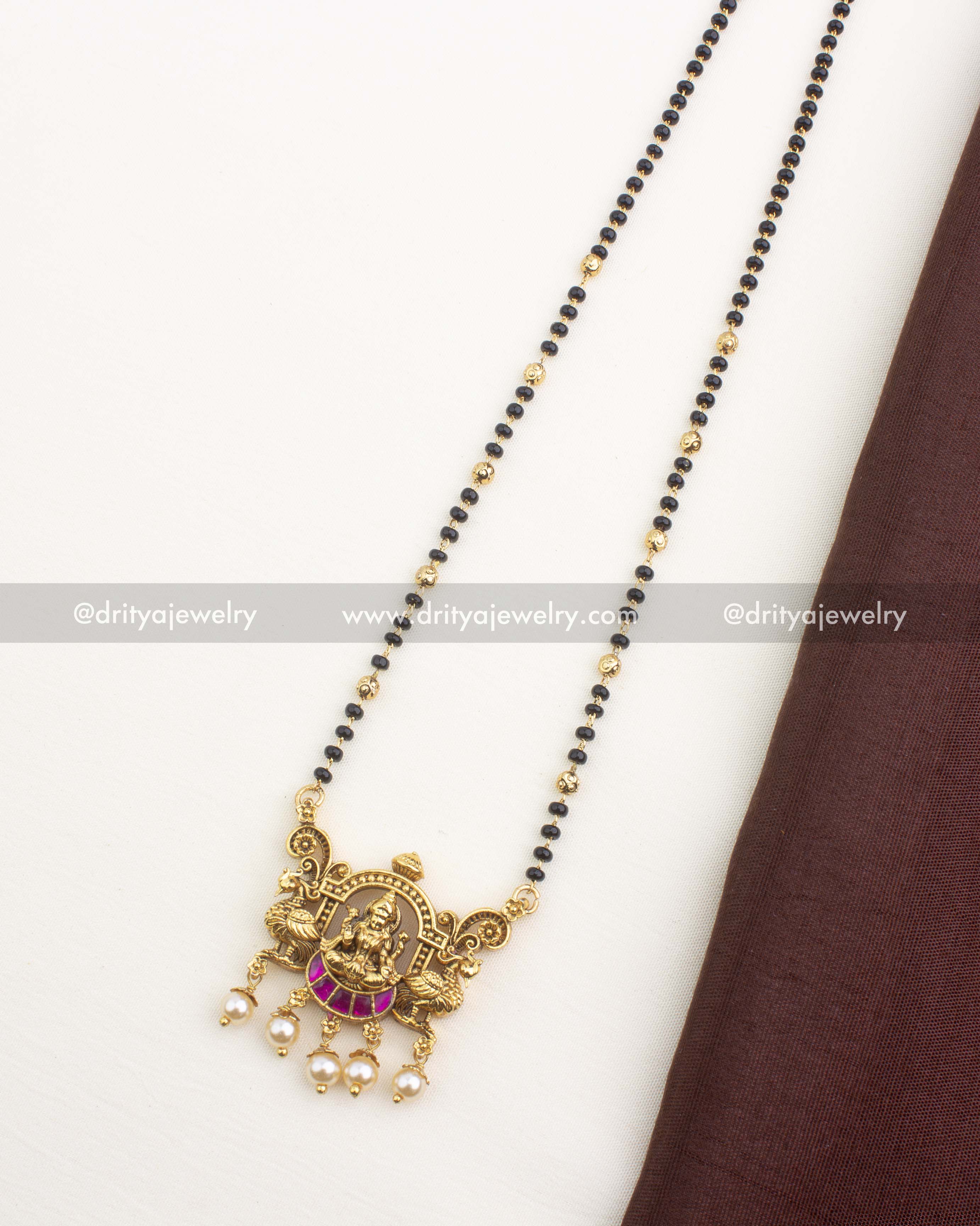 Antique gold Lakshmi pendant necklace with black beads, kemp stones, and pearl drops, 18-inch length.