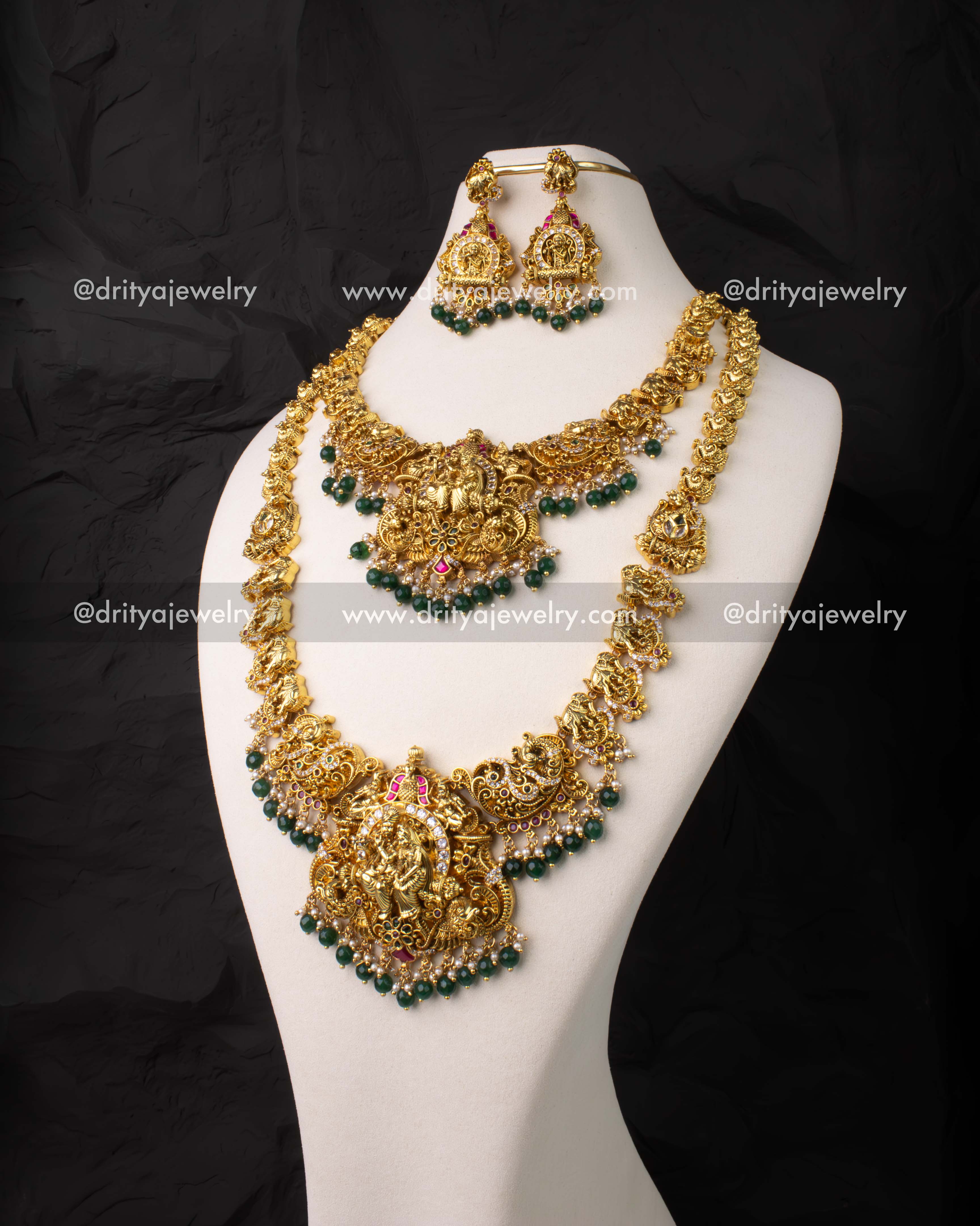 Traditional 4-piece bridal jewelry set with Lakshmi motifs in antique gold finish and kemp stones.