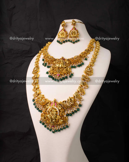 Traditional 4-piece bridal jewelry set with Lakshmi motifs in antique gold finish and kemp stones.