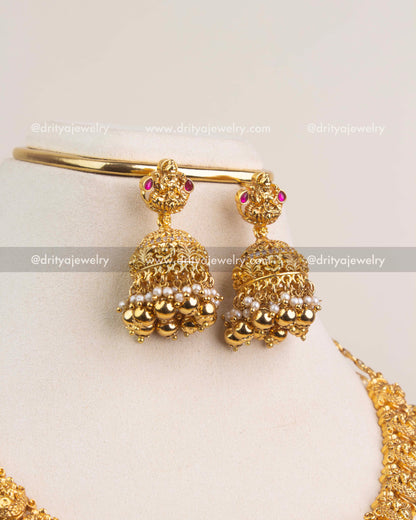 Matching temple jhumkas with ruby stones, gold beads, and pearl detailing.
