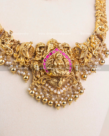 Close-up of short temple necklace pendant featuring Lakshmi motif and ruby Kemp border.
