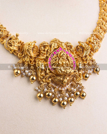 Detailed view of Lakshmi Devi Nakshi pendant with ruby Kemp stones and pearl hangings.