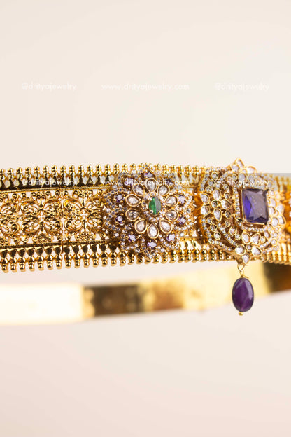 Handcrafted floral design featuring kundan stones, CZ detailing, and violet centerpiece.