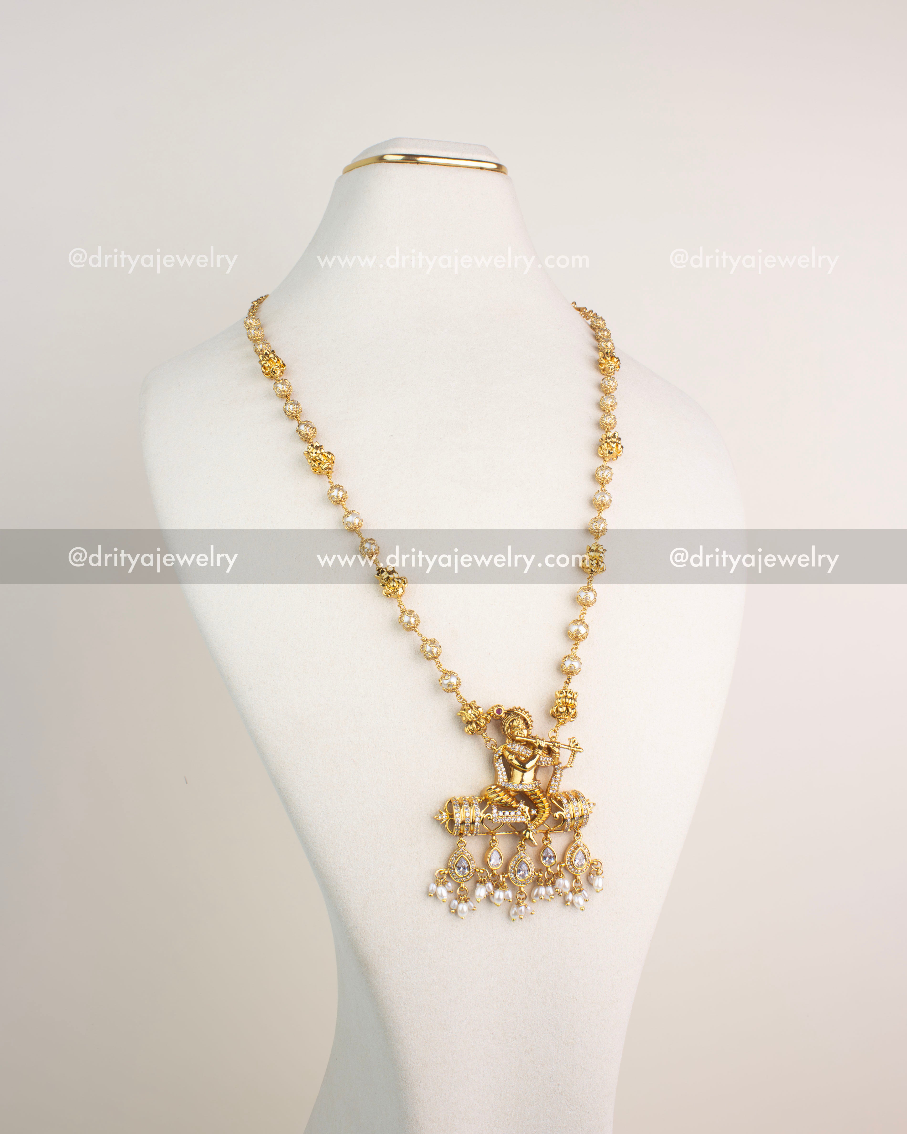 Gold-plated necklace with Lord Krishna pendant, CZ detailing, and pearl drops.