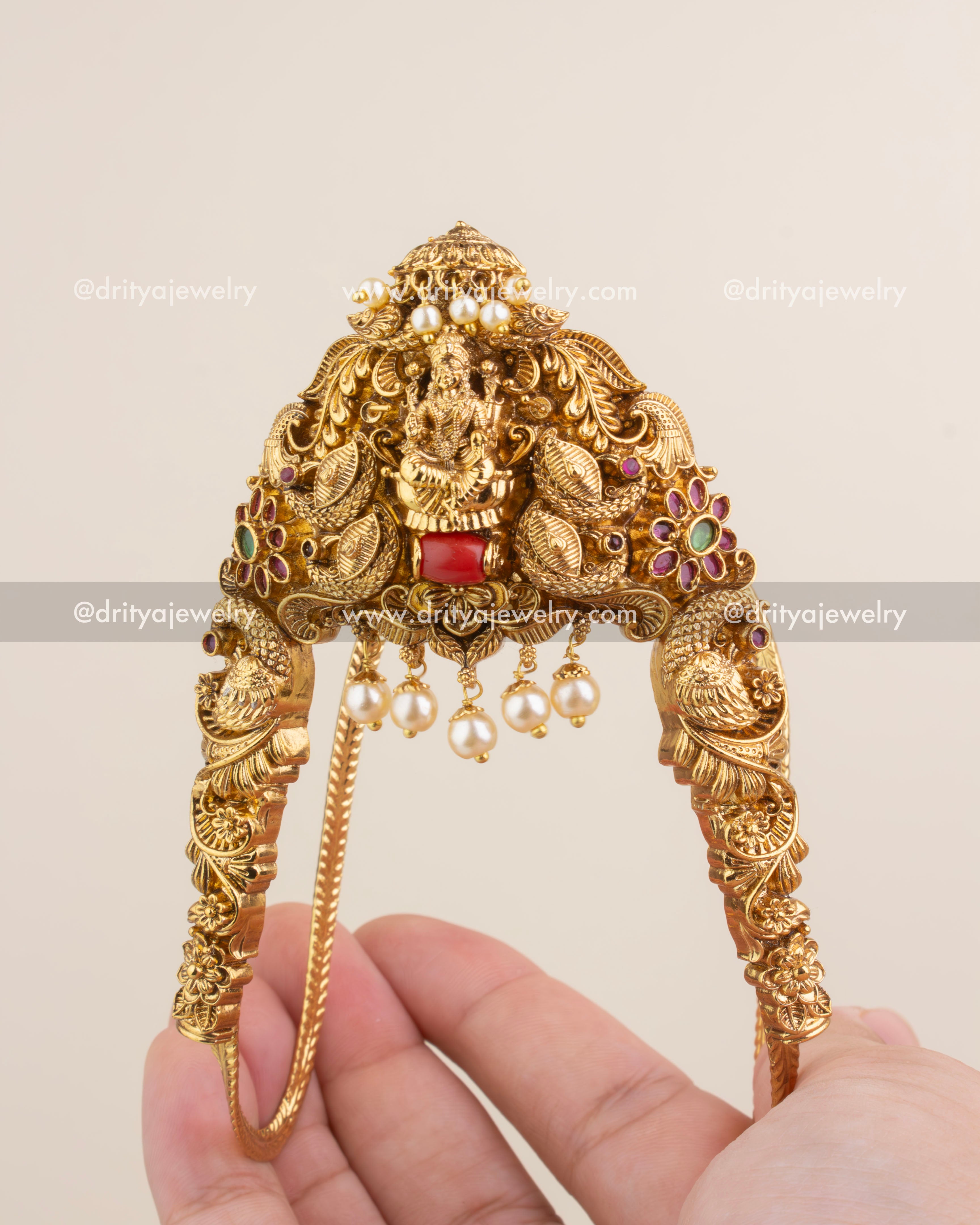 Antique gold Aravanki featuring Lakshmi motif, coral bead, peacock carvings, and pearl hangings.