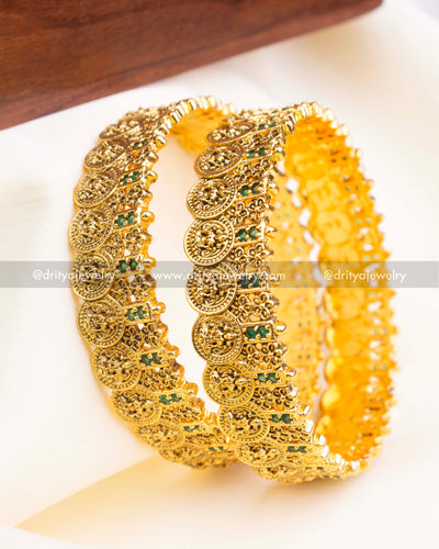 Styled image of the bangle pair highlighting embossed Lakshmi motifs and antique polish.