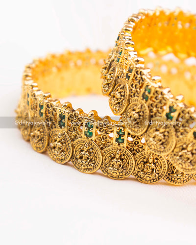 Side angle showing the intricate green stone placement and coin pattern on nakshi bangles.