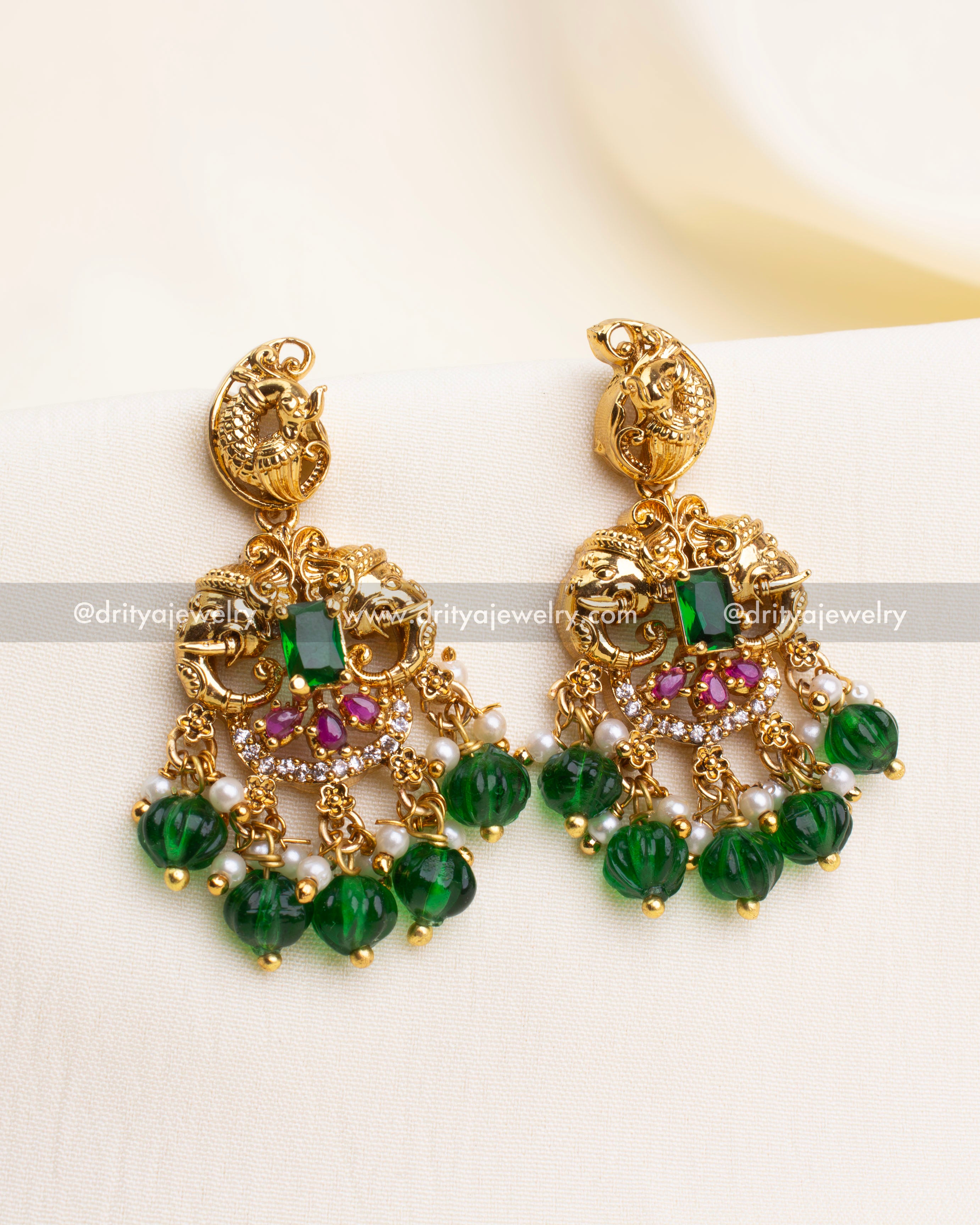 Antique gold danglers with nakshi peacock top, pink stones, and green carved bead hangings.