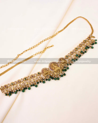 Gold-plated Nakshi hip chain with Goddess Lakshmi motifs, ruby-green accents, and bead drops.