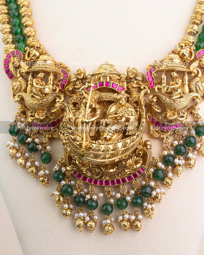 3D Nakshi pendant with Lord Krishna design, ruby Kemp detailing, and pearl-green bead accents.