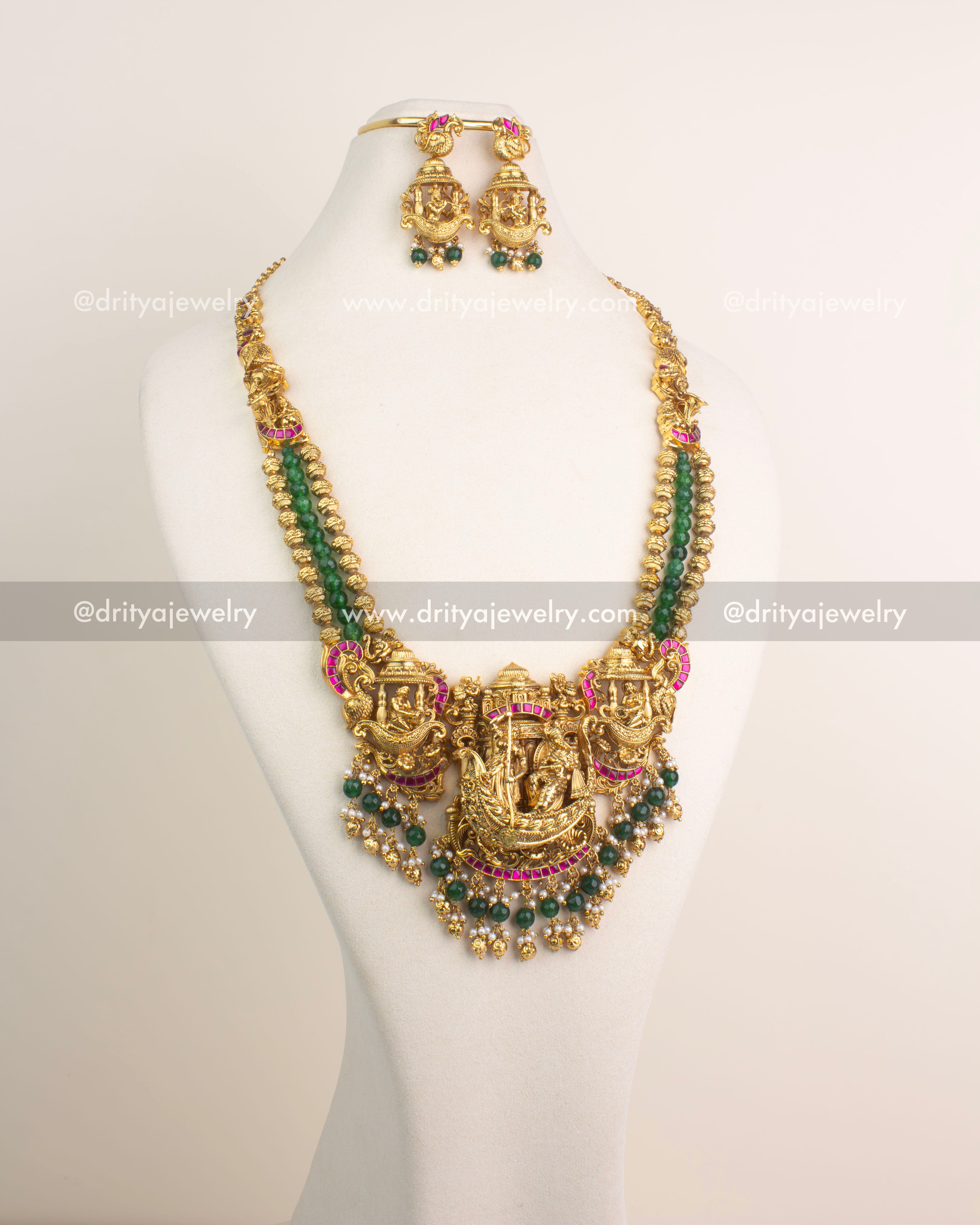 Antique gold Nakshi long haram featuring Lord Krishna boat motif with ruby Kemp stones and emerald green bead hangings.