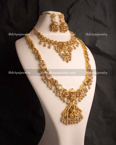 Gold-plated Nakshi long necklace set with intricate deity carvings, Kundan stones, and pearl drops.