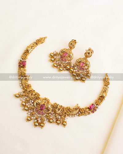 Short antique gold necklace with peacock, yali face motifs, ruby pink stones, and pearl-gold bead detailing.
