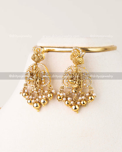 Traditional long haram set featuring Nakshi Ram Parivar motif, AD stones, and pearl drops in antique gold finish.