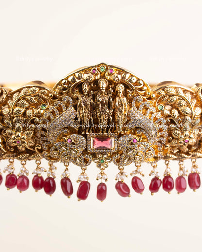 Handcrafted Nakshi detailing with CZ stones, floral carvings, and ruby centerpiece.