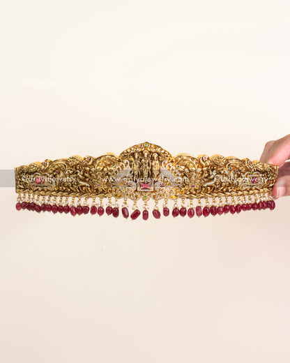Antique gold Nakshi vadanam featuring Ram Parivar motif with ruby bead drops.