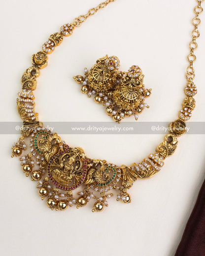 Antique gold temple necklace with Lakshmi motif, peacock design, and gold ball danglings.