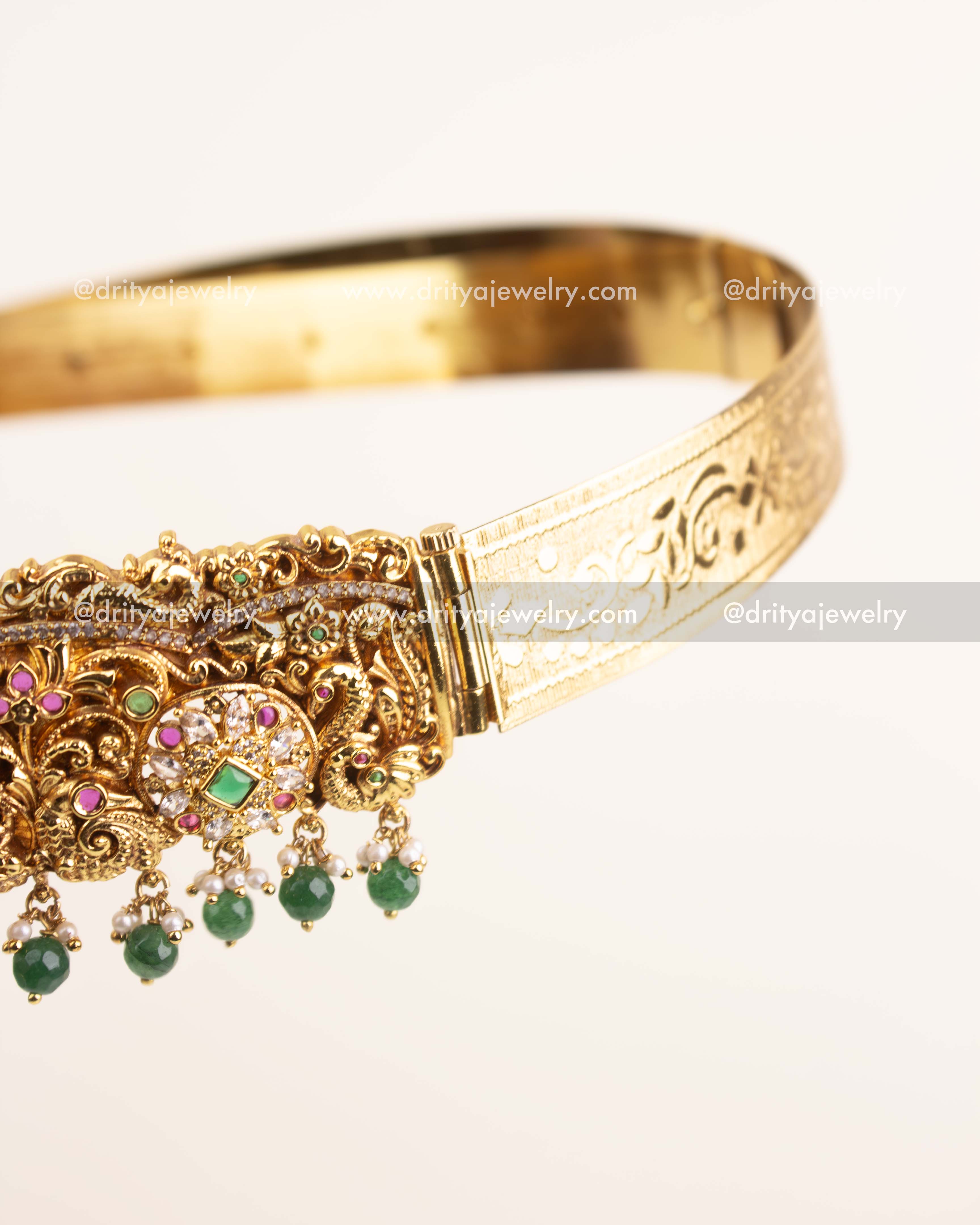 Side view showcasing antique gold floral Nakshi work and emerald bead detailing.