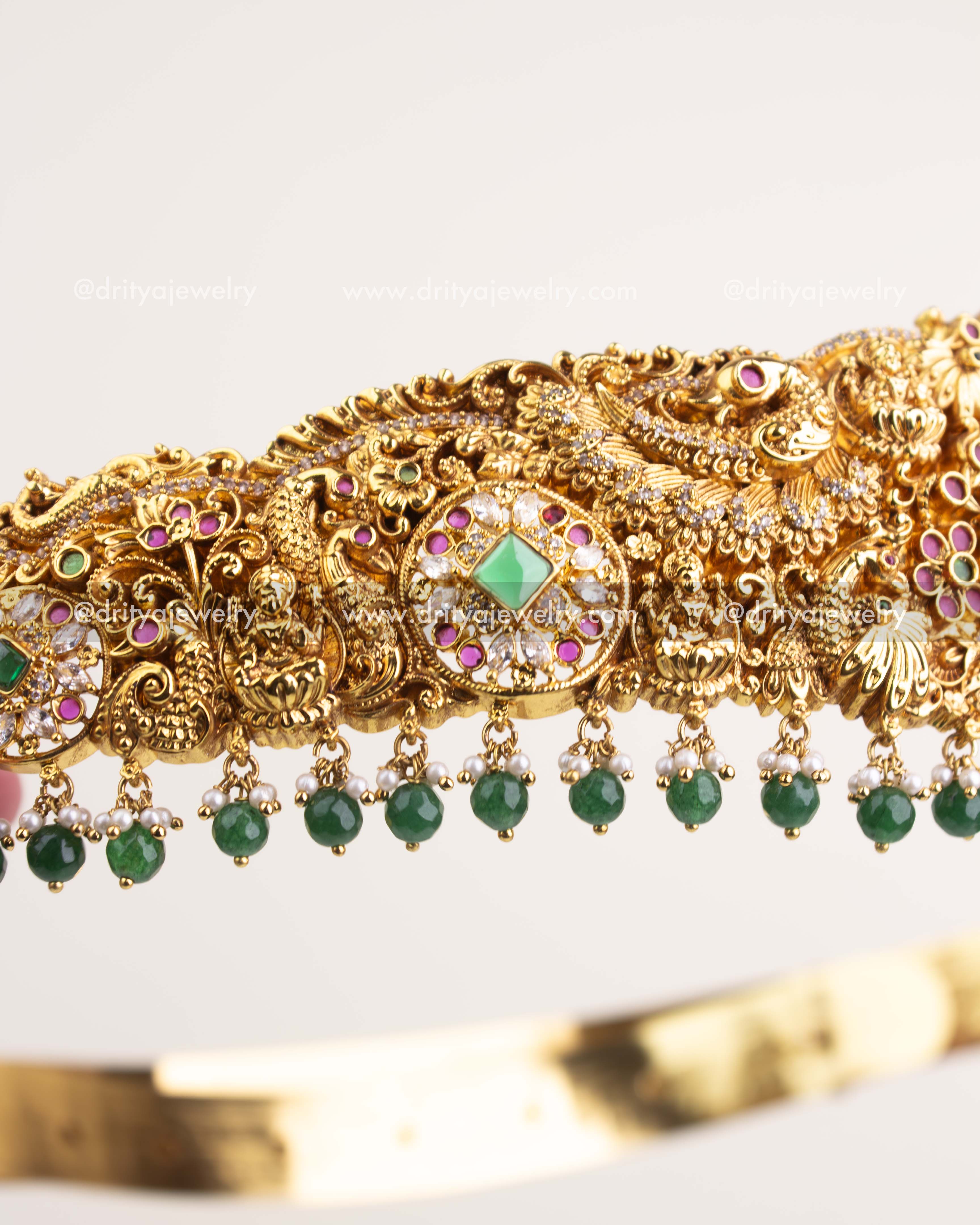 Side view showcasing antique gold floral Nakshi work and emerald bead detailing.