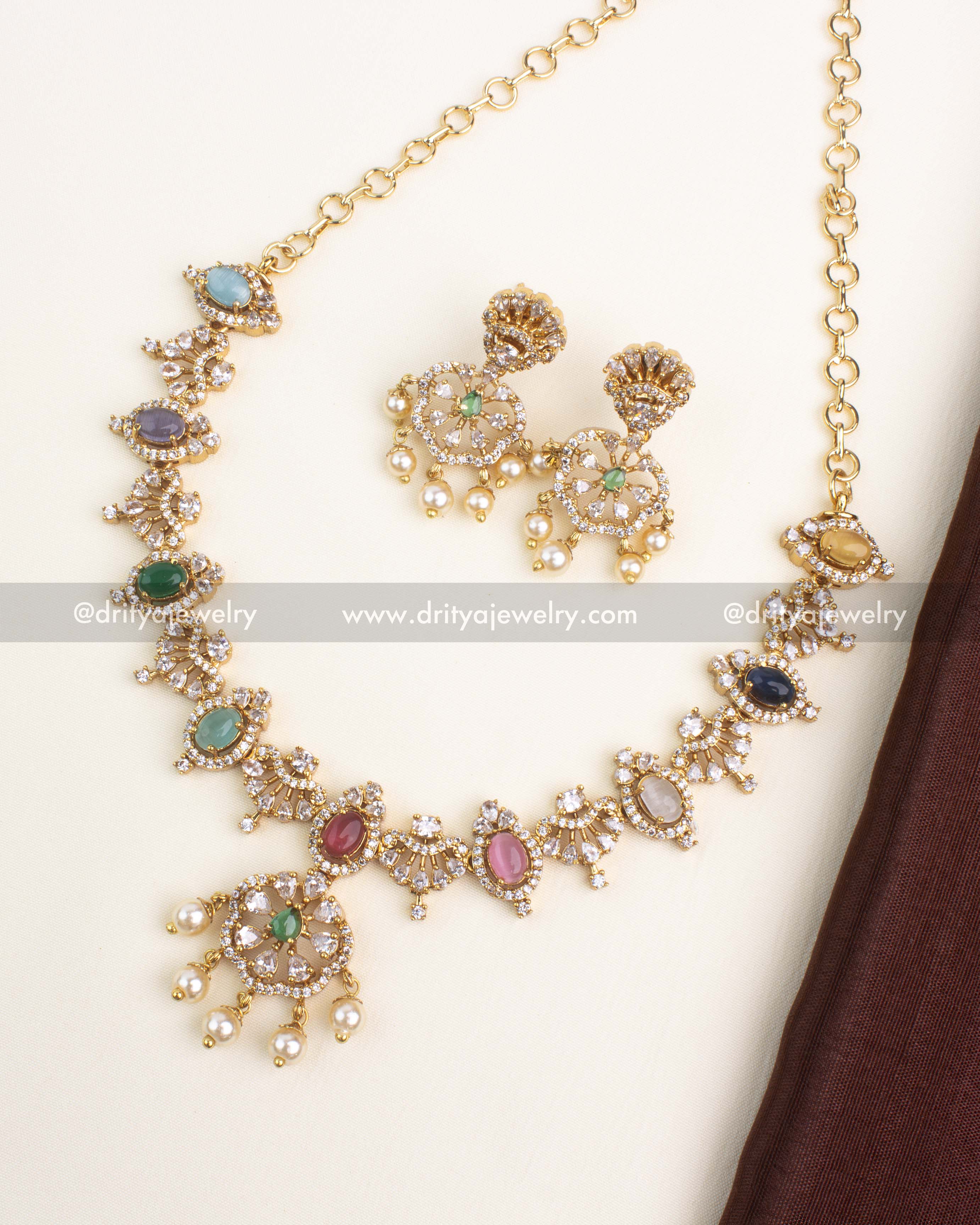 Gold-plated navaratna short necklace with multicolor oval stones, CZ halo detailing, and matching pearl dangler earrings by Dritya Jewelry.