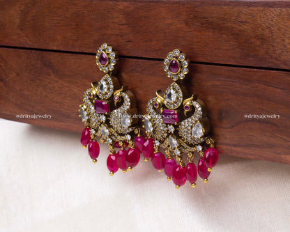 Elegant Victorian-style peacock motif earrings with pink bead hangings and faux gemstone embellishments, perfect for formal attire.