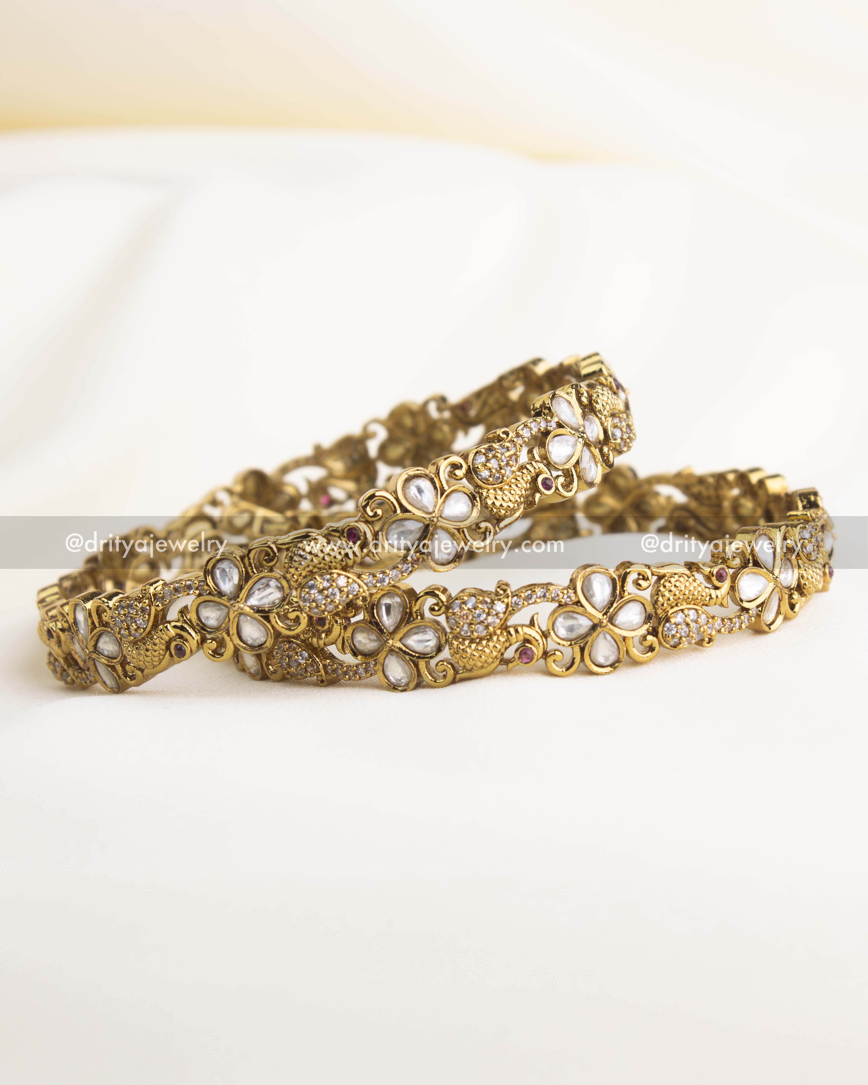 Victorian-polished bangle set with floral Polki motifs and antique gold detailing.