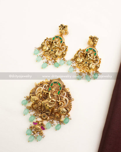 Antique gold Radha Krishna temple pendant set with mint-green beads, pearl hangings, and matching earrings.