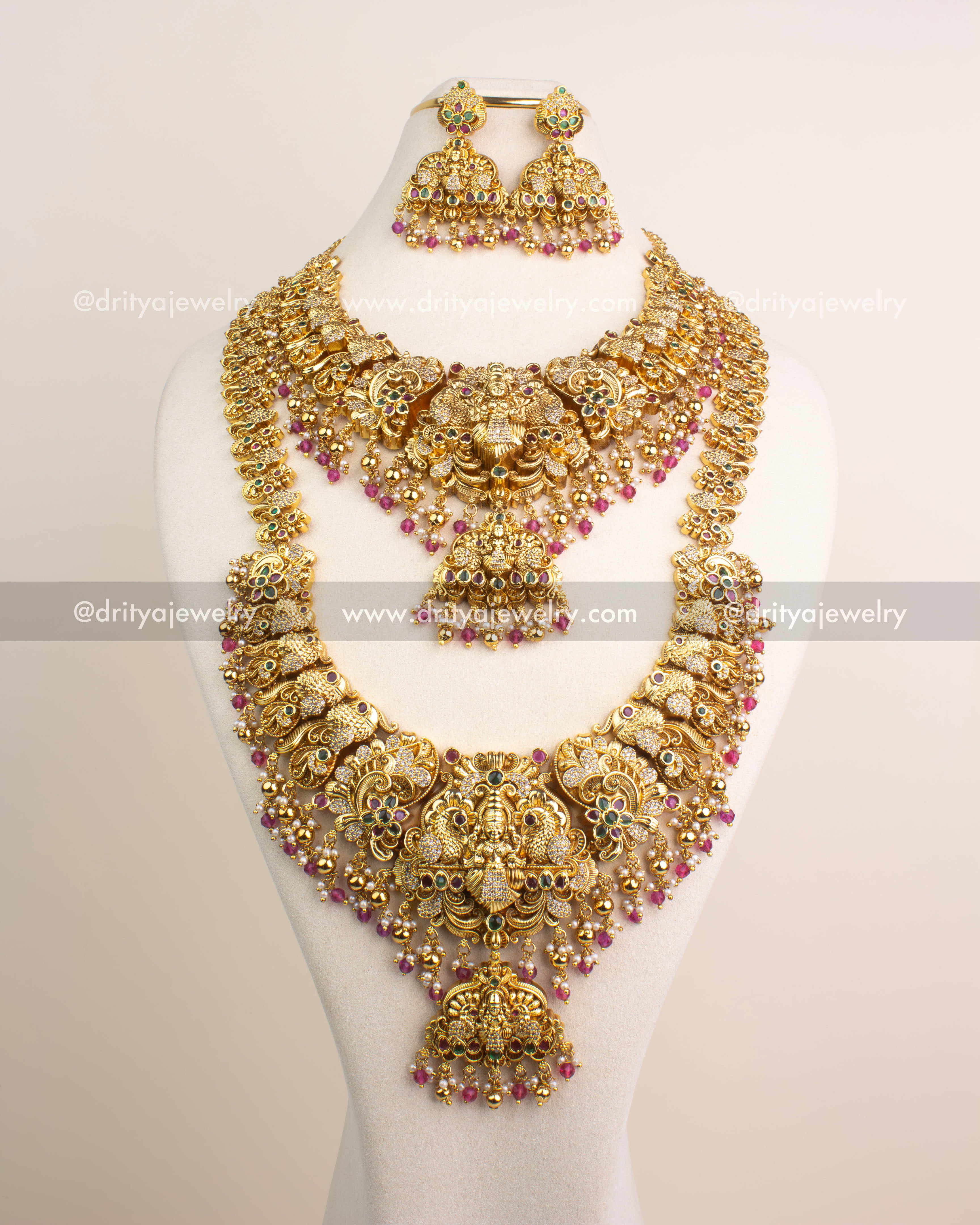 Antique gold temple bridal jewelry set featuring Lakshmi motifs, CZ stone accents, and ruby pink bead drops.