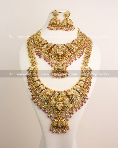 Antique gold temple bridal jewelry set featuring Lakshmi motifs, CZ stone accents, and ruby pink bead drops.
