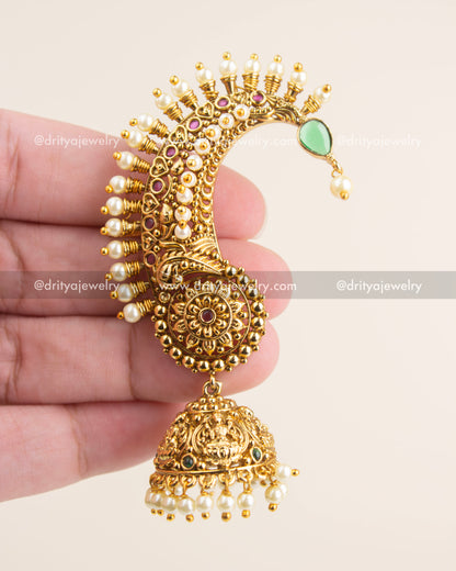 Close-up of traditional South Indian temple ear cuff with Nakshi carvings, ruby stones, and pearl detailing.
