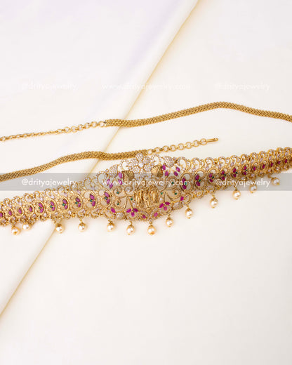 Gold-plated temple-style hip chain featuring Lakshmi motif, ruby accents, and pearl drops.