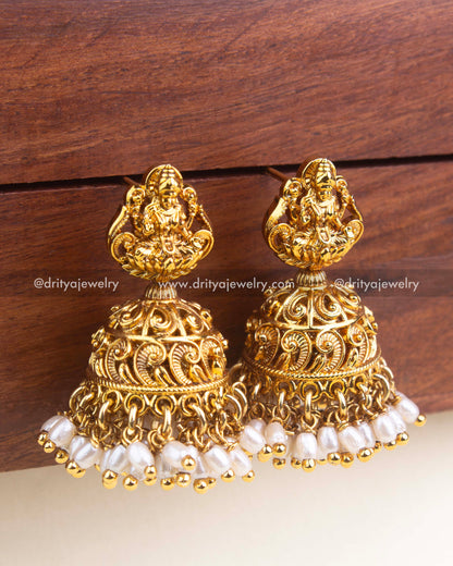 Close-up of nakshi temple jhumka showing intricate dome carving and rice bead pearl fringe.