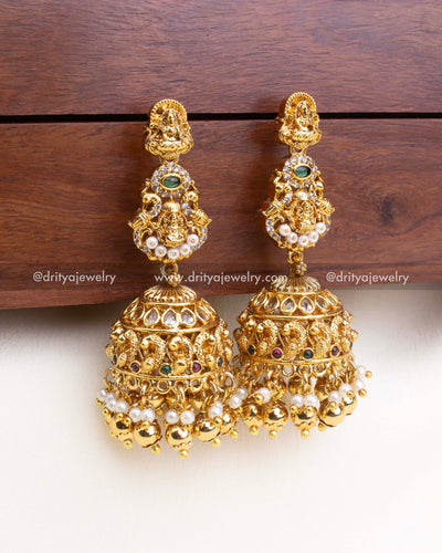 Detailed temple-style jhumka with deity carvings, multicolor stones, and dome hangings.