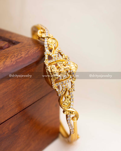 Openable temple kada with Lakshmi motif, gold polish, and CZ stone detailing.