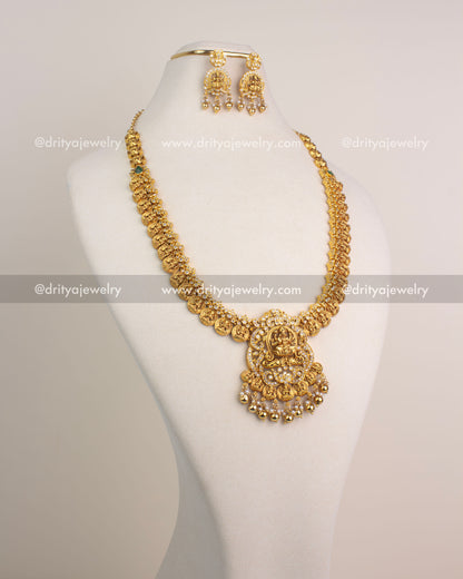 Traditional temple long haram with Lakshmi Devi pendant and Kasulu coin chain detailing in gold finish.